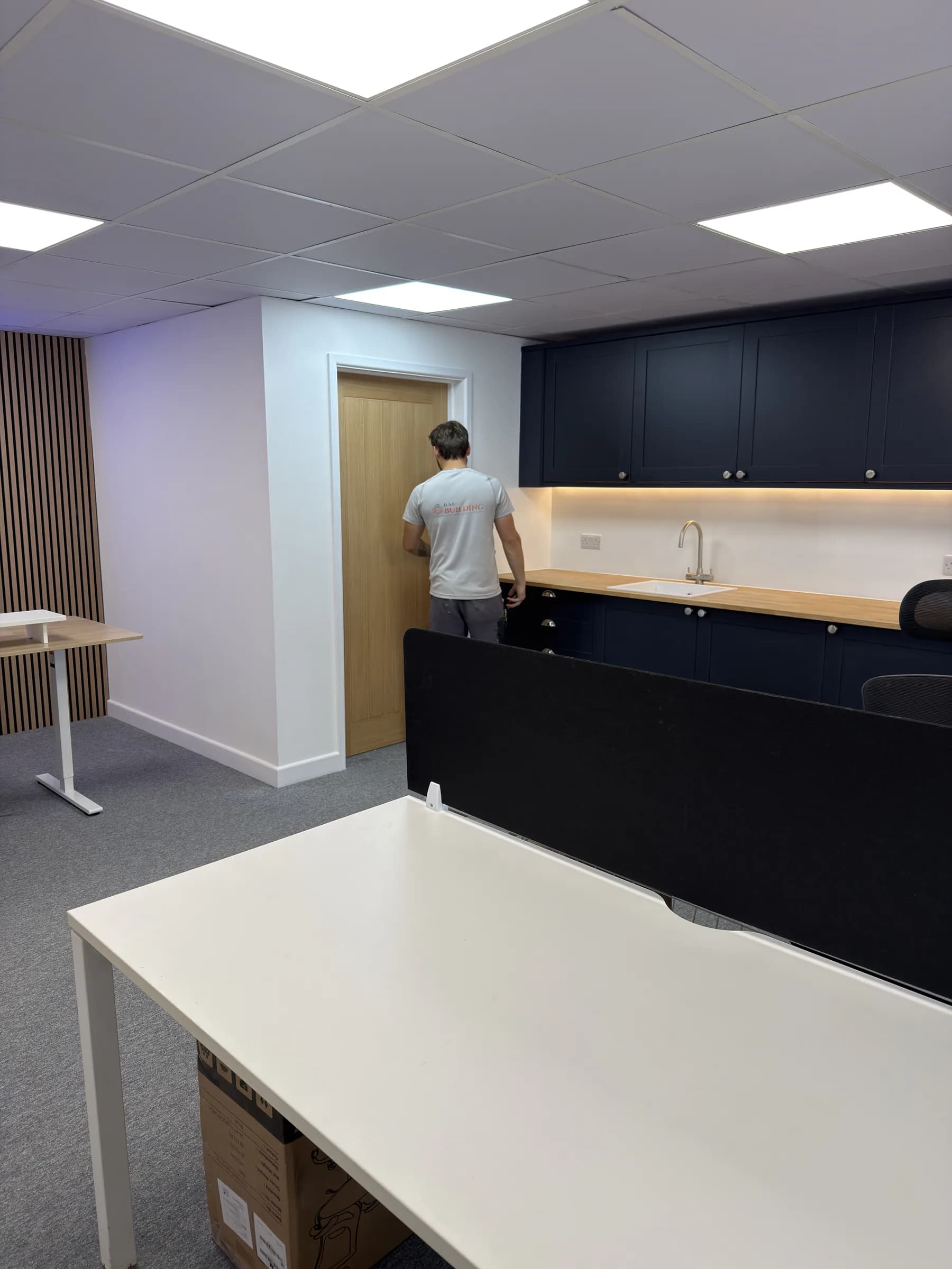 Final checks to the oak door and fitted kitchenette in the commercial office
