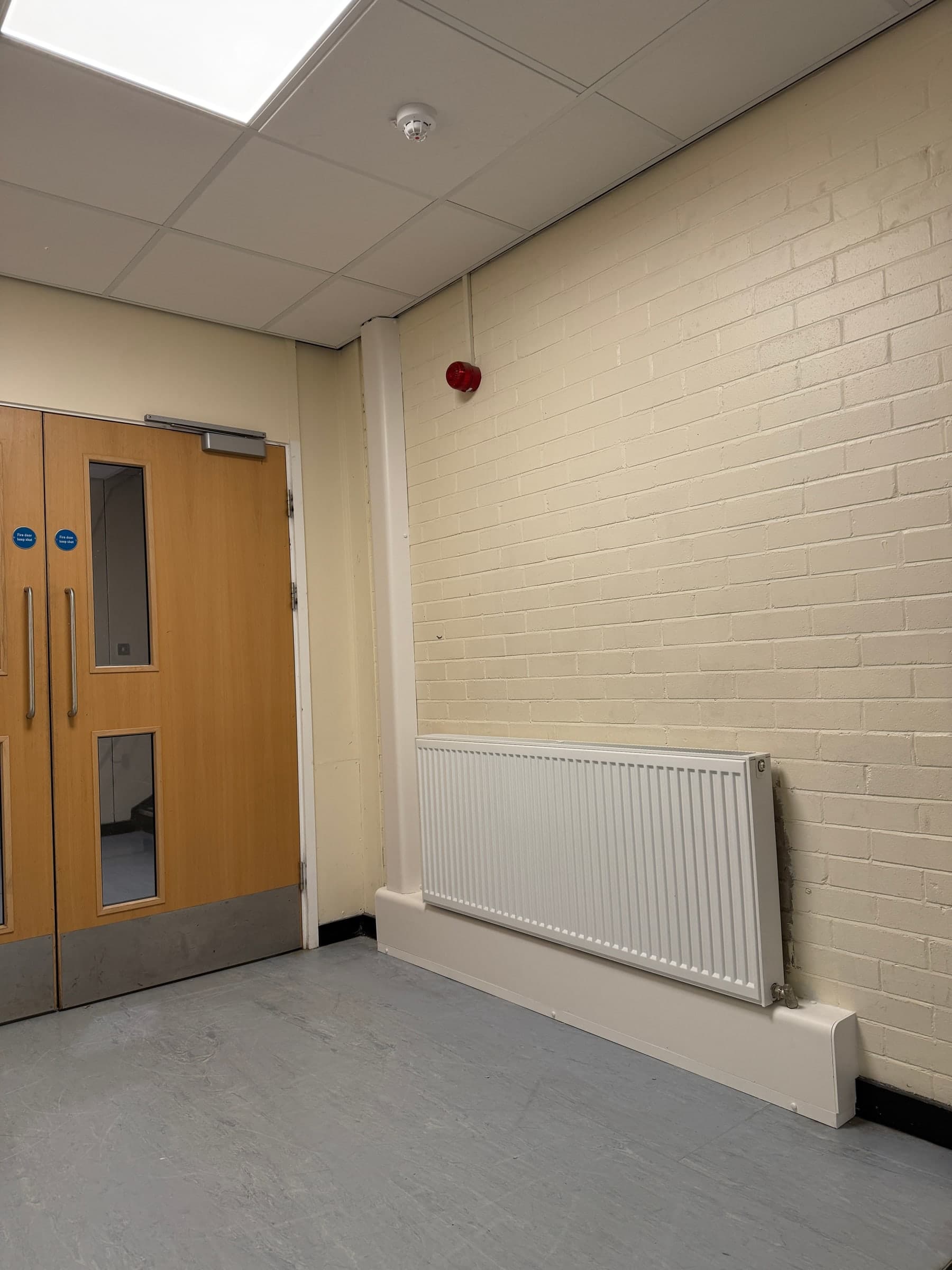 Completed commercial pipe encasement in a corridor