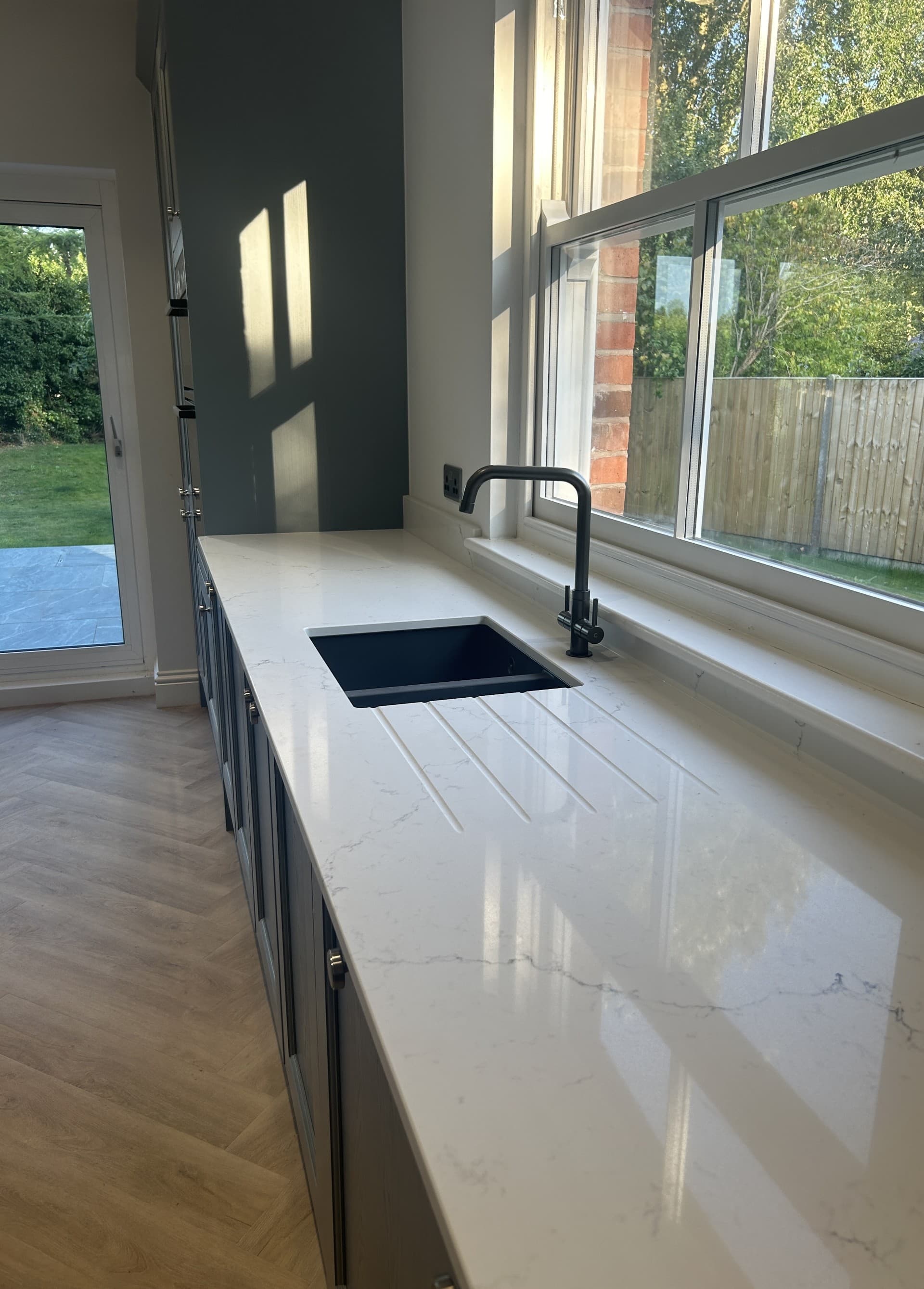 Finished kitchen sink and worktop detail with black tap