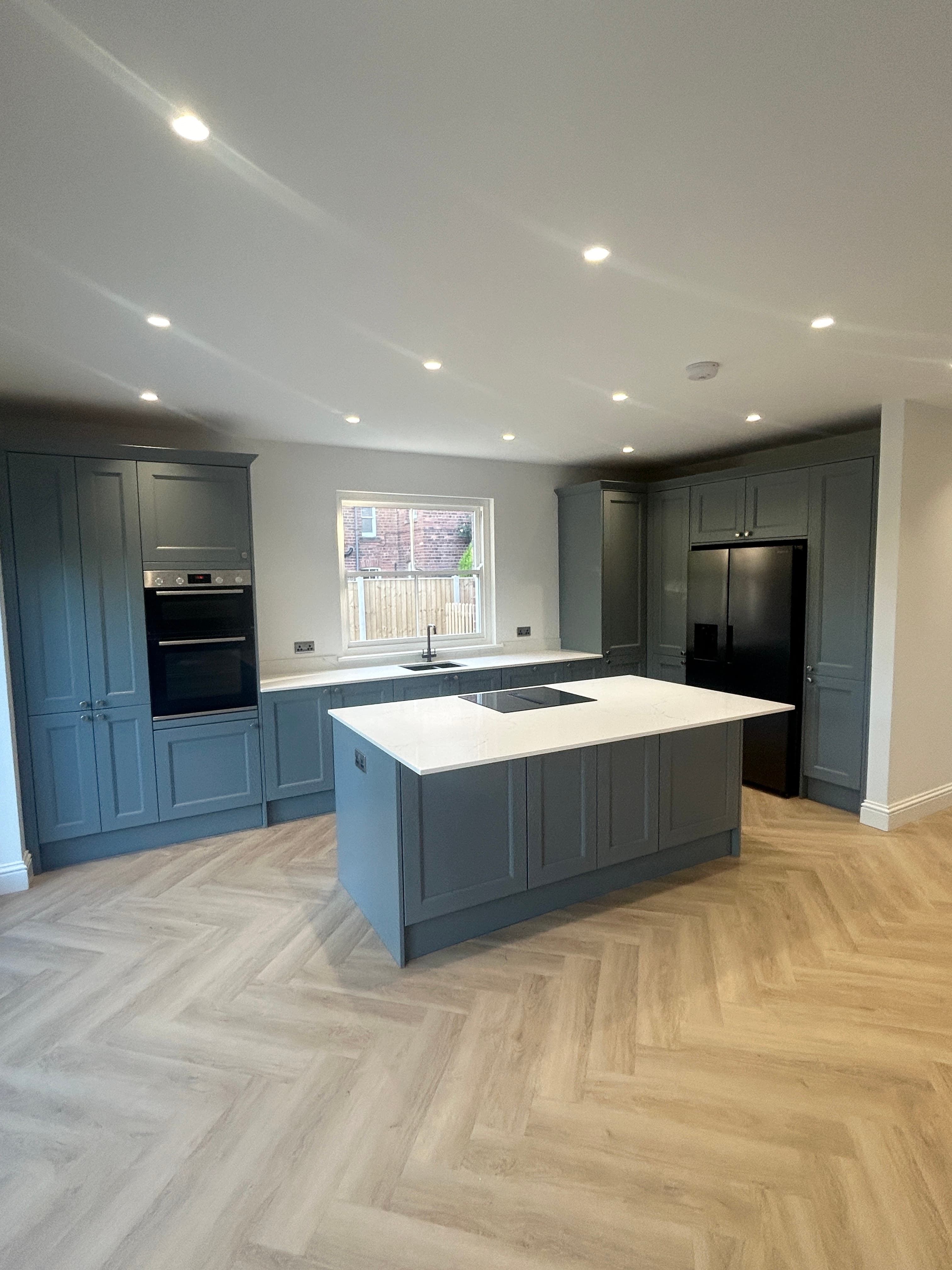 Finished open-plan kitchen renovation with grey shaker units and island
